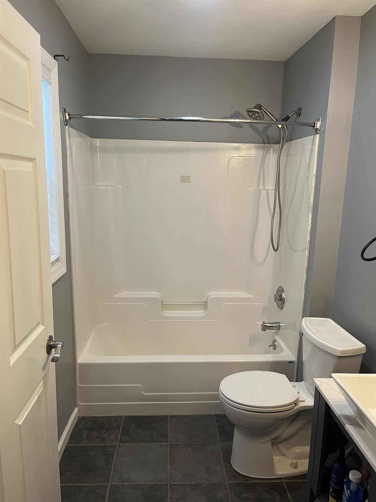 Before: worn fiberglass shower stall with curtain